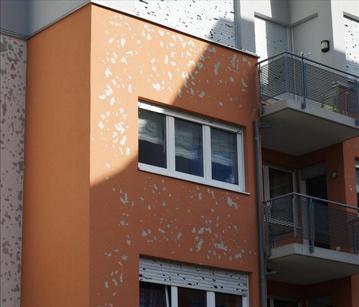 orange and white commercial building with hail damage